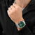 Pulsera de hombre en la muñeca: esfera verde, correa de acero inoxidable y ventana de fecha