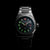 Reloj de hombre con caja plateada y esfera negra con marcadores luminosos.