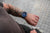 Reloj de hombre en la muñeca con correa de cuero azul y esfera azul