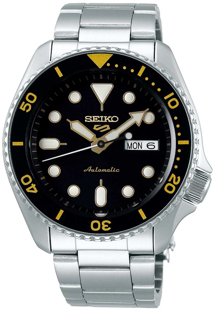 Reloj de hombre con esfera negra, detalles amarillos y correa de metal, automático