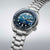 Reloj de hombre vista lateral: esfera azul, bisel y pulsera de acero inoxidable