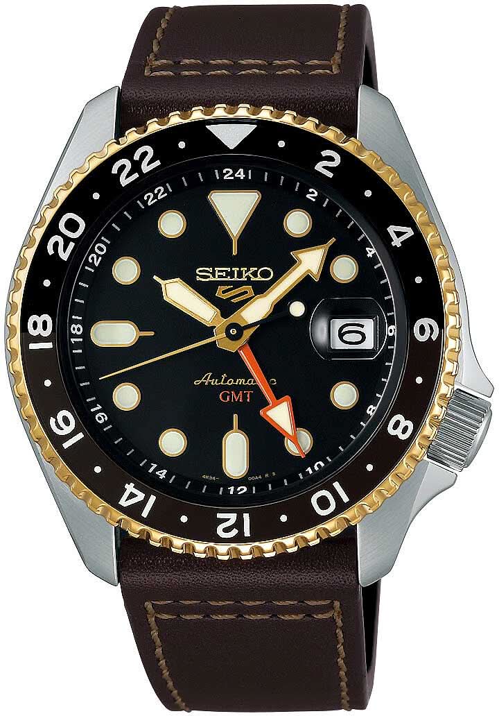 Reloj de hombre con esfera negra, bisel dorado y correa de cuero marrón.