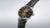 Reloj de hombre con correa de cuero negra y esfera dorada radiante, corona lateral