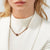 Collar con colgante de acero inoxidable en forma de cilindro en una fina cinta rosa