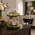 Reloj de mesa mecánico con campana de cristal, borde dorado y base verde, números romanos