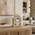 Reloj de mesa de madera clara con esfera redonda, números romanos e indicador de fases lunares