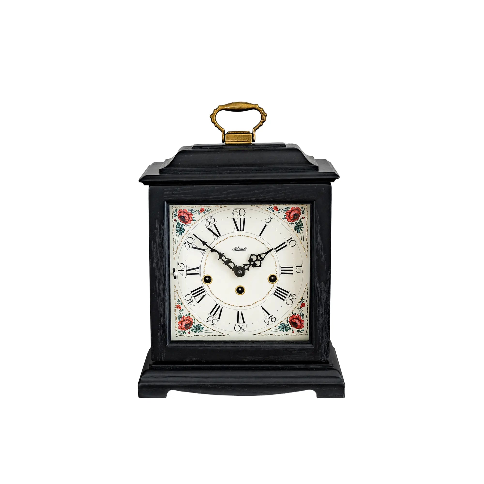 Reloj de mesa negro con esfera floral y asa dorada, cuerda mecánica