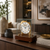 Reloj de mesa en caja de cristal con esfera blanca, elementos de latón y base de nogal
