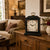 Reloj de mesa negro con carcasa de madera, asa dorada y esfera con estampado floral