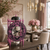 Reloj de mesa con marco morado y números ornamentales, movimiento visiblemente montado