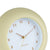 Großaufnahme Wanduhr Softgelb: geriffelter Rand, goldene Zeiger und Ziffern