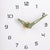 Nahaufnahme Wanduhr: grüne Zeiger, schwarze Ziffern und goldfarbenes Uhrwerk