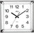 Reloj de pared cuadrado con marco negro, números blancos y manecillas negras