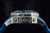 Reverso de reloj de pulsera para hombre de metal con relieve y borde protector, con correa azul visible