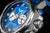Pulsera de hombre en detalle: vista lateral con corona y pulsador, esfera azul