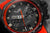 Reloj de hombre con esfera negra, bisel rojo y manecillas luminosas distintivas