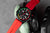 Reloj de hombre con correa roja, esfera negra redonda con subesferas