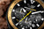 Reloj solar para hombre: esfera negra con segundero de cronógrafo amarillo y bisel dorado