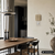 Wanduhr an der Wand mit Holz-Zifferblatt, Metallrahmen und silbernem Pendel