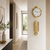 Reloj de pared dorado con péndulos decorativos en la pared del pasillo