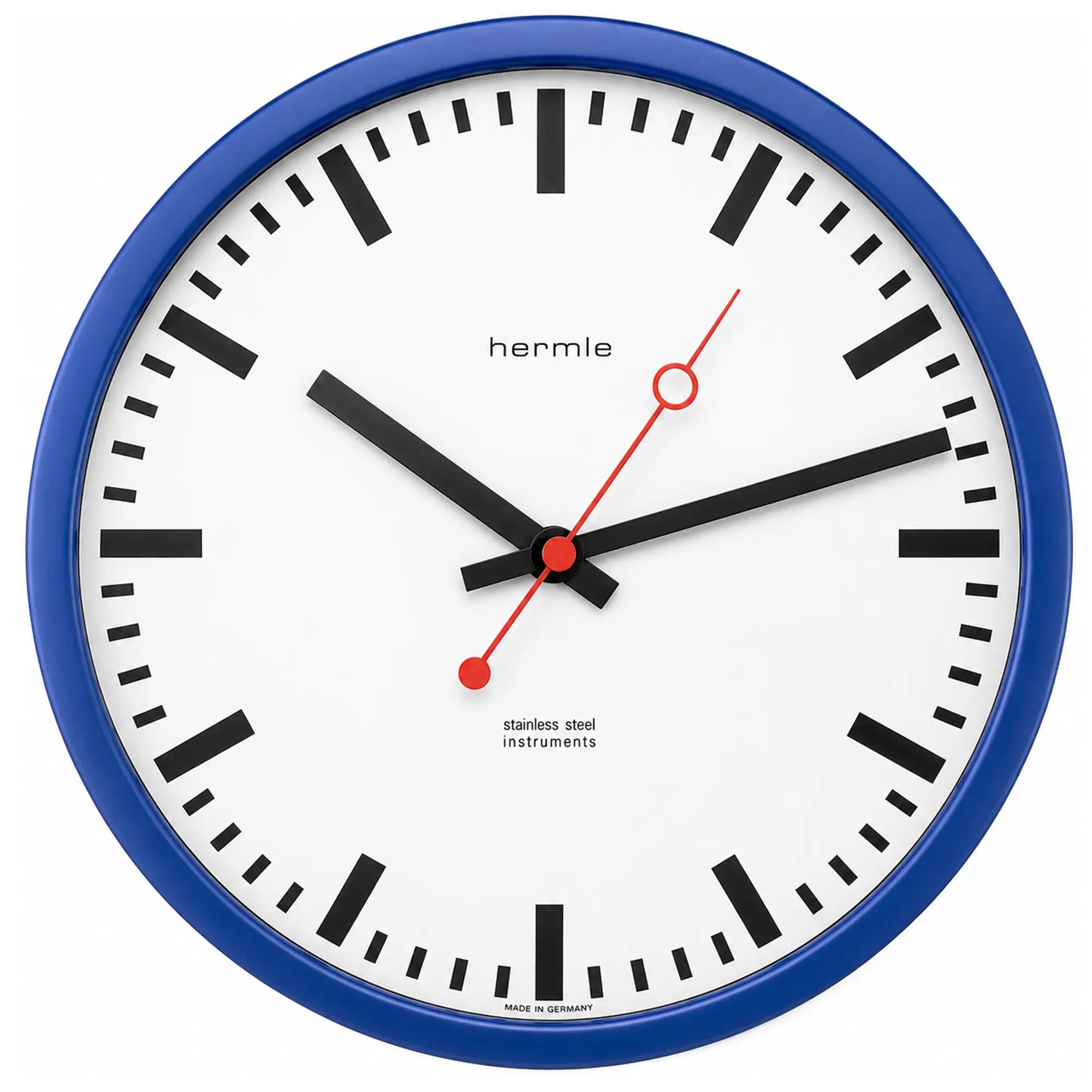 Reloj de pared radiocontrolado con marco azul, esfera blanca, manecillas rojas y marcas de índice negras