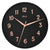 Reloj de pared redondo: esfera negra, manecillas y números en oro rosa, inscripción Hermle