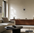Wanduhr mit dunkler Ziffernfläche und Aluminium-Stäben, kompakte runde Form
