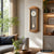 Wanduhr mit Holzgehäuse in Eicheoptik, Pendel sichtbar, über Sofa an der Wand