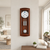 Reloj de pared de madera en marco de madera con esfera redonda, péndulo y gran gong, en la pared