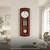 Holz-Wanduhr mit rundem Zifferblatt, Glasfront und zwei Pendelgewichten im Uhrgehäuse