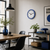 Reloj de pared con marco azul, esfera blanca, manecillas rojas y marcas de índice negras