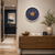 Reloj de pared con esfera ornamental azul, motivos dorados, centro de madera y manecillas blancas