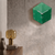 Reloj de pared de acrílico con caja cúbica verde, manecillas y números blancos en la pared