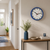 "Reloj de pared con borde azul y esfera blanca, segundero rojo"