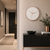 Reloj de pared con marco redondo de metal color oro rosa y esfera blanca sobre pared beige