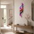 Reloj de pared con diseño de ondas de colores, péndulo morado y números blancos en la pared