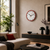 Reloj de pared con borde rojo sobre sofá y aparador