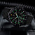 Reloj de hombre con caja redonda negra y números luminosos, correa de textil negro