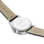 Pulsera de hombre con tapa trasera de metal y correa de cuero beige, vista inferior en primer plano.