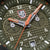 Detalle de reloj para hombre: manecillas naranjas, logotipo "LUMINOX" y anillo de esfera con indicación de 200 metros