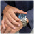 Reloj de hombre en la muñeca con esfera azul y pulsera de metal plateado