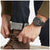 Reloj de hombre en la muñeca con correa negra y esfera oscura.
