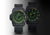 Reloj de hombre en pareja: dos modelos negros con esfera verde y correa de tela