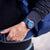 Reloj de hombre en la muñeca con esfera azul y correa azul oscuro