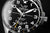 alt
Esfera de reloj para hombre primer plano: diseño negro, manecillas plateadas, logo Space Race