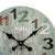 Detailansicht: Runde Wanduhr mit grünlichem Zifferblatt, schwarzen Zeigern und Ziffern 1–3.