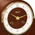 Reloj de mesa de madera en caja de madera con esfera redonda, manecillas doradas y logo Hermle