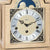 Frente de reloj de mesa de madera con ventana de fases lunares, marcadores de hora romanos y manecillas negras