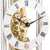 Mecanismo de reloj de mesa con engranajes dorados y números romanos en esfera blanca