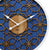 "Reloj de pared en detalle: esfera azul con adornos florales dorados, disco de madera, manecillas"
